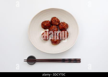 gnocchi di carne con salsa agrodolce su sfondo bianco Foto Stock