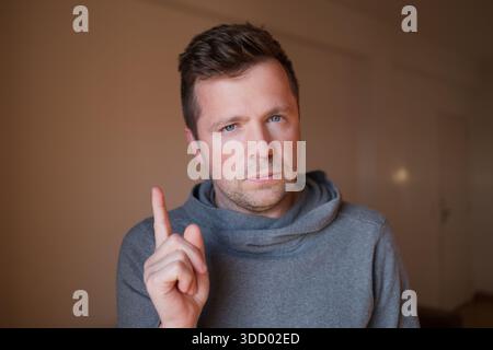 Uomo europeo di mezza età che punta con Index Finger Foto Stock