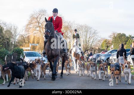 La parata di caccia Puckeridge e Essex Union Hunt il giorno di Santo Stefano nel villaggio rurale di Matching Green. Cacciatore e cacciatori di volatili che vanno nel villaggio Foto Stock