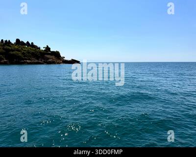 Mare blu ondulato con riflessi del sole e cielo limpido Foto Stock