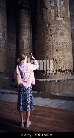 Donna che scatta una foto all'interno dell'antico tempio egizio Foto Stock