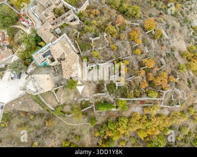 Vista aerea dall'alto verso il basso di una fortezza del XII secolo nascosta tra le montagne rocciose dell'Abruzzo, Italia Foto Stock