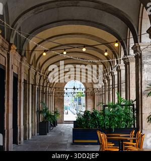 Passaggio arcade sotto gli edifici in stile classico con spesse colonne nel quartiere gotico di Barcellona. Foto Stock