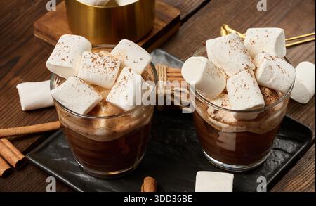 Due bicchieri di cioccolata calda con soffici marshmallow su una tavola di ardesia. Un primo piano della bevanda invernale. Vista dall'alto Foto Stock