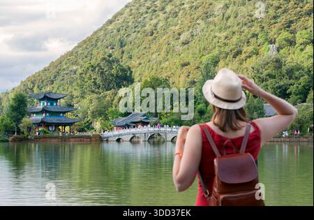 Giovane donna viaggiatrice che viaggia al punto di riferimento della Black Dragon Pool e luogo popolare per le attrazioni turistiche vicino alla città vecchia di Lijiang. Lijiang, Yunnan, Cina Foto Stock