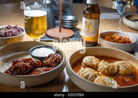 Gnocchi Mandu in salsa Buldak calda, ali di pollo Kimchi e coreana con salsa Gochujang e salsa Aioli serviti in un ristorante coreano Foto Stock