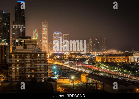 Paesaggio urbano notturno dello skyline del centro di Chicago con grattacieli illuminati, scie di luci dei semafori su Lake Shore Drive e il Field Museum. Foto Stock