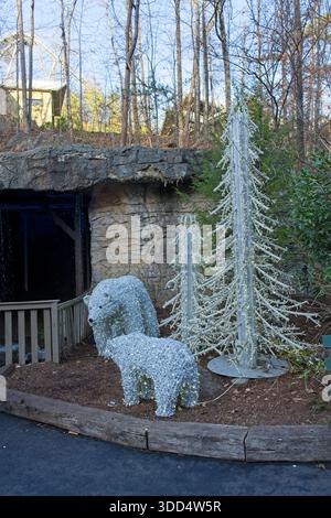 Decorazioni natalizie di famiglia di orsi polari a filo illuminato e alberi in un ambiente boschivo Foto Stock