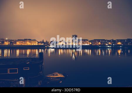 Panorama notturno di Novi Sad, Serbia, con skyline illuminato della città splendidamente riflesso nelle calme acque del Danubio per viaggi e notti urbane Foto Stock