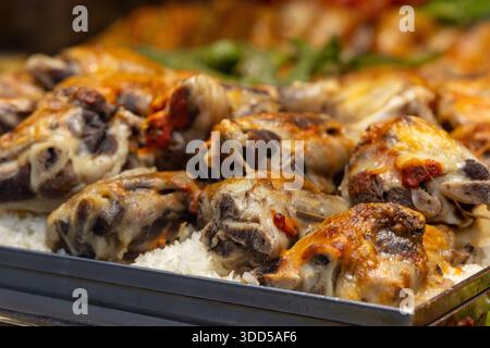 Primo piano di cosce di pollo arrosto servite su un tradizionale pilaf di riso su un piatto in un ristorante Foto Stock