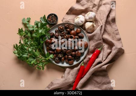 Piatto con gustosi funghi fritti e diversi ingredienti su sfondo beige Foto Stock