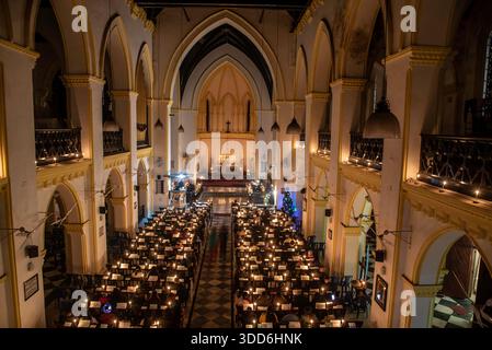 Kolkata, Bengala Occidentale, India. 26 dicembre 2025. Cristiani provenienti da diverse parti di Calcutta partecipano alla preghiera di messa di mezzanotte di Natale nella chiesa di San Giacomo a Entally, Calcutta, una delle chiese più eleganti di Calcutta, il 24 dicembre 2025 a mezzanotte per osservare la vigilia di Natale e preghiere speciali il giorno di Natale. La chiesa di San Giacomo (C.N.I), Calcutta, che è una chiesa anglicana a Calcutta, Bengala Occidentale, India, è una delle chiese più eleganti di Calcutta. Costruita nel 1862, le guglie gemelle della chiesa di San Giacomo dominano lo skyline di Kolkata. È popolarmente conosciuta come Jora Girja, letteralmente gemella coira Foto Stock