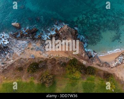 Veduta aerea dall'alto verso il basso della costa rocciosa e delle acque cristalline turchesi Foto Stock
