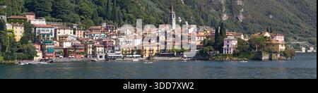 Varenna, Italia - 21 agosto 2021: Vista panoramica del lungomare di Varenna vista dal lago di Como, con colorate case storiche, caffetterie, bar, ecc. Foto Stock