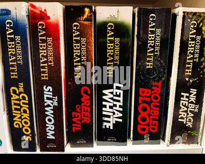 Londra, Regno Unito - 12 dicembre 2025: Sei romanzi di Robert Galbraith su una libreria, spine audaci e atmosfera misteriosa. Foto Stock