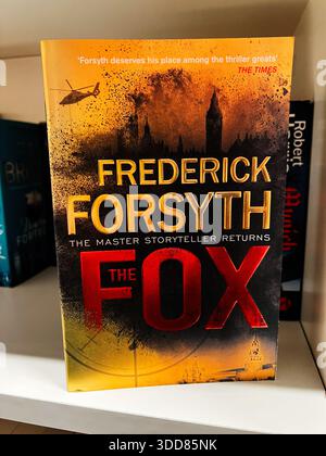 Londra, Regno Unito - 12 dicembre 2025: Copertina di un romanzo thriller The Fox di Forsyth, caratterizzato da un design arancione e rosso. Foto Stock