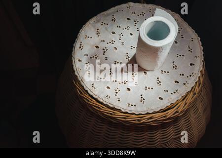 Composizione astratta della carta igienica su una ruota di vimini vista dall'alto. Foto Stock