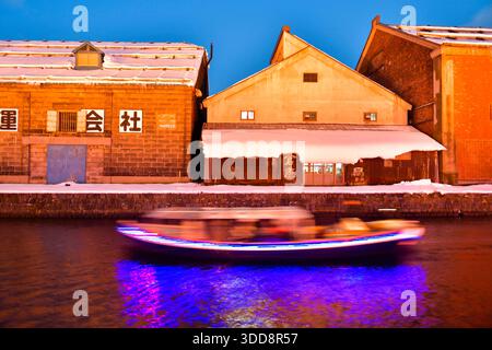 Il canale dell'acqua di Otaru e gli edifici lungo il lungomare all'aperto in inverno di notte a Hokkaido, Otaru, Giappone Foto Stock