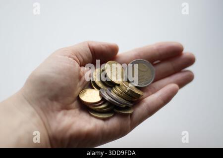 Donna che tiene in mano monete in euro, primo piano Foto Stock