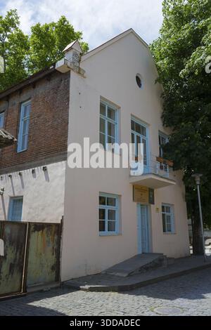 Edificio a due piani con mattoni e porta blu, circondato da alberi in una giornata di sole, edificio amministrativo di Katharinenfeld, restauro 2019-2021, Boln Foto Stock