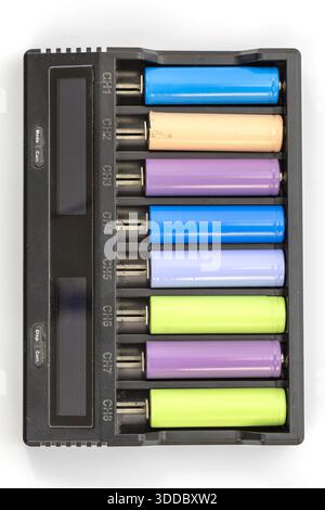 Vista dall'alto di un caricabatteria a otto canali con batterie di vari colori inserite. Il caricabatterie è in plastica nera e mostra le etichette dei canali CH1 Foto Stock