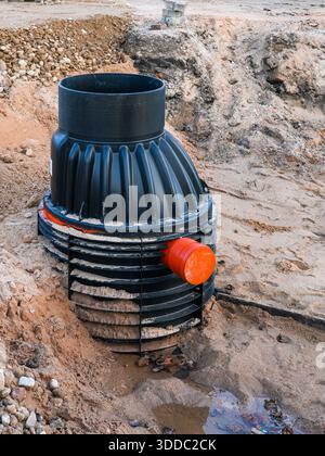 Installazione della camera di tombino di drenaggio sotterraneo in plastica nel sito con scavo esposto del terreno Foto Stock