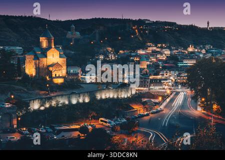 31 ottobre 2025, Tbilisi, Georgia: Città vecchia che brilla di notte con sentieri leggeri da auto in movimento, che mostrano la chiesa di Metekhi Foto Stock