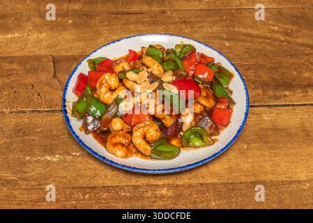 Gambero Kung Pao con verdure assortite come mais, carote e sedano, in una versione più mite e adatta alle famiglie, guarnita con semi di sesamo Foto Stock