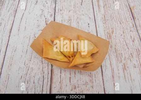 Wonton in stile Fusion ripieni di pollo teriyaki e verdure, serviti in una presentazione moderna con purea di edamame e fiocchi di alghe nori tostati Foto Stock