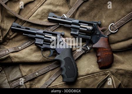 Un paio di classici revolver neri su sfondo tela Foto Stock