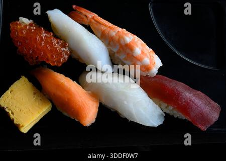 Sushi e sushi roll su un tavolo in pietra nera. Cucina tradizionale asiatica, Tokyo, Giappone. Foto Stock