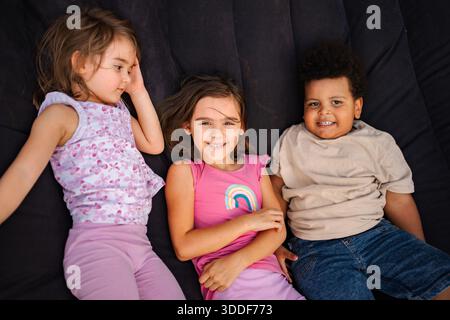 Bambini diversi amici che si trovano insieme sorridendo godendo l'infanzia Foto Stock