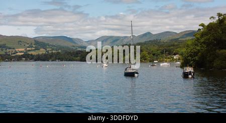 Barche a vela ormeggiate su un lago del Lake District con colline sullo sfondo Foto Stock