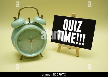 Messaggio di testo dell'ora del quiz e sveglia su sfondo giallo Foto Stock