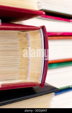 Primo piano di album fotografici impilati con copertine rosse, che mostrano i bordi della pagina e i dettagli della rilegatura. Foto Stock