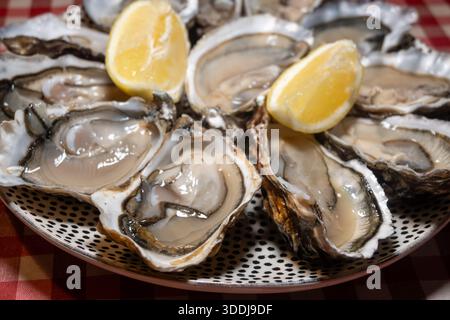 Ostriche fresche sul mercato francese settimanale, cibo di strada, porzione di ostriche aperte con limone, pesce, Francia, primo piano Foto Stock