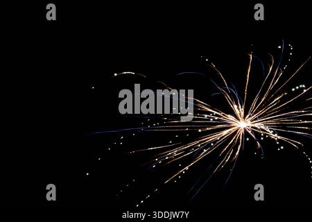 I vivaci fuochi d'artificio mostrano raffiche luminose e ruscelli scintillanti nel cielo notturno Foto Stock