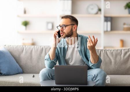 Ha sottolineato i giovani freelance che utilizzano il computer portatile e che effettuano chiamate con lo smartphone a casa Foto Stock