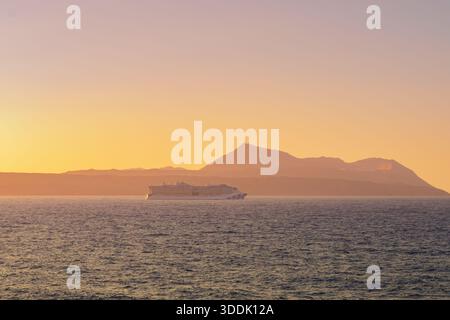 Souda, Grecia. 22 giugno 2025. La grande nave da crociera Sun Princess naviga in mare aperto contro un suggestivo paesaggio arancione al tramonto Foto Stock