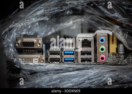 Pannello i-o posteriore della scheda madre per PC desktop che mostra le uscite video VGA e DVI, più porte USB, un connettore femmina Ethernet RJ45 e prese audio con codifica a colori utilizzate Foto Stock