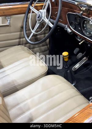Vista interna dettagliata di un'auto d'epoca, interni di un'automobile d'epoca. Auto di lusso retrò. volante classico, leva del cambio, pedali e quadro strumenti Foto Stock