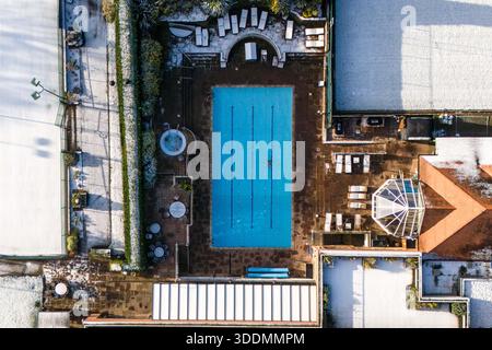 Edgbaston, Birmingham 2 gennaio 2026 - l'Edgbaston Priory Tennis Club è stato colpito dalla neve, colpendo tutti tranne un nuotatore solitario fuori. - Neve sui tetti nella zona di Edgbaston a Birmingham come un turbinio si sistemò durante la notte. L'Edgbaston Priory Tennis Club è stato colpito e un nuotatore solitario ha apprezzato la piscina riscaldata all'aperto circondata da campi da tennis coperti di neve. Grandi campi della, chiusi per Natale, la scuola privata Priory (Edgbaston) sembrava un biglietto di Natale e lo skyline di Birmingham sembrava audace contro un cielo fresco con tetti innevati che vi conducevano. I Warwickshire Bears Edgbaston Stad Foto Stock