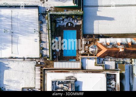 Edgbaston, Birmingham 2 gennaio 2026 - l'Edgbaston Priory Tennis Club è stato colpito dalla neve, colpendo tutti tranne un nuotatore solitario fuori. - Neve sui tetti nella zona di Edgbaston a Birmingham come un turbinio si sistemò durante la notte. L'Edgbaston Priory Tennis Club è stato colpito e un nuotatore solitario ha apprezzato la piscina riscaldata all'aperto circondata da campi da tennis coperti di neve. Grandi campi della, chiusi per Natale, la scuola privata Priory (Edgbaston) sembrava un biglietto di Natale e lo skyline di Birmingham sembrava audace contro un cielo fresco con tetti innevati che vi conducevano. I Warwickshire Bears Edgbaston Stad Foto Stock