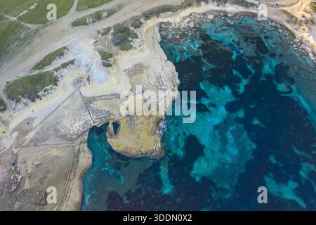 Vista aerea della costa frastagliata, dove le acque turchesi incontrano le pallide scogliere di Mistra Bay, St. Paul's Bay, Malta. Foto Stock