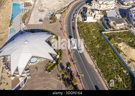 Vista aerea della piscina di Qawra vicino alla costa rocciosa, il mare blu che contrasta con la pietra abbronzata, Bugibba, la baia di St. Paul, Malta. Foto Stock