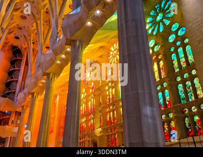 Interni della Sagrada Familia, presi dal sole pomeridiano che scorre attraverso vetrate colorate Foto Stock
