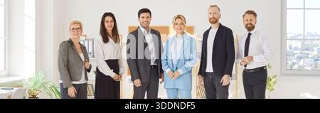 Ritratto di gruppo del team aziendale di successo e del personale aziendale in piedi nello spazio ufficio. Colleghi allegri sorridenti in abiti casual eleganti Foto Stock