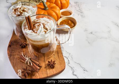 Due lattine di zucca con panna montata su marmo Foto Stock