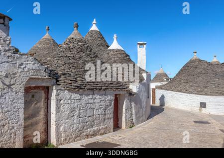 Fila di iconiche case di trullo ad Alberobello, Bari, Italia meridionale. I trulli di Alberobello sono stati dichiarati patrimonio dell'umanità dell'UNESCO. Foto Stock