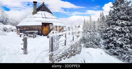Cottage tradizionali in legno su un altopiano innevato, Velika Planina, Slovenia. Paesaggi invernali sulle montagne delle Alpi Slocveniane Foto Stock
